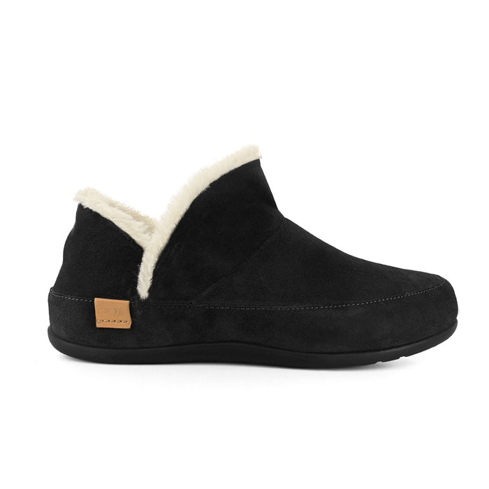 The STRIVE Strive Womens Geneva Black slipper is shown in side profile against a white background, featuring black suede, a cream fluffy lining, tan leather heel tag, and a supportive biomechanical footbed.