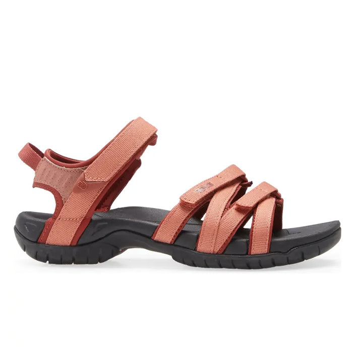 The Teva Womens Tirra Aragon sandal features a rust color, black sole, adjustable Velcro straps, and added arch support—ideal for outdoor or casual wear.