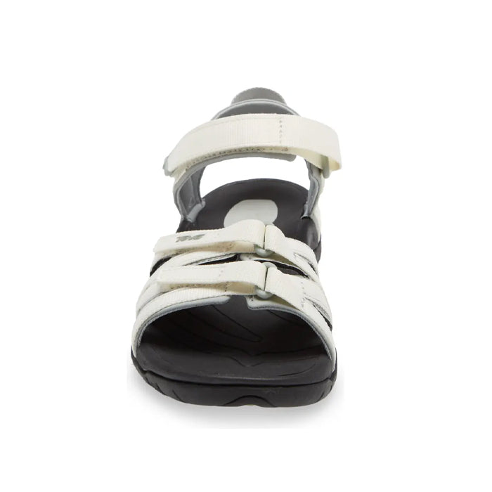 The Teva Womens Tirra in White/Black features adjustable straps, an open toe, a supportive black sole for all-day comfort, and is shown front-facing against a white background.
