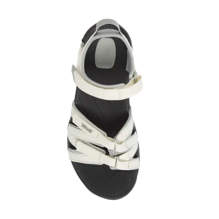 A top view of the Teva Womens Tirra White/Black sandal by Teva, featuring an open toe, black sole, and white adjustable straps, designed for comfort, arch support, and versatile everyday wear.