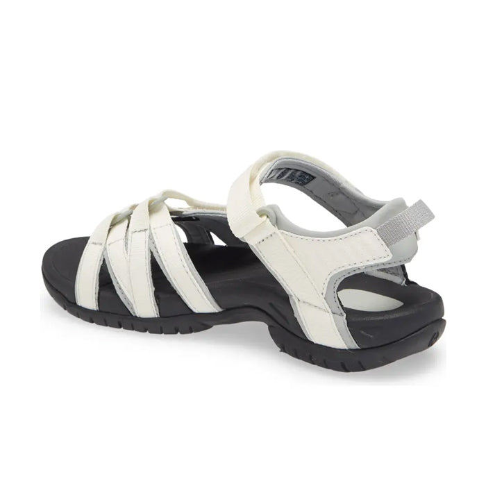 The Teva Womens Tirra in White/Black is a multi-purpose sandal with arch support, adjustable Velcro ankle strap, open toe, and rugged tread. Shown angled on a white background.