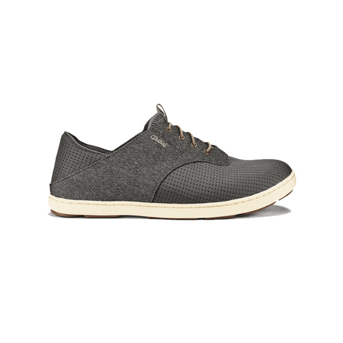 The OluKai Mens Nohea Moku in Charcoal/Clay features a dark gray textured fabric upper, perforated sides and toe, tan stitching, anatomical midsole, and light beige rubber sole. Shown in side profile on a white background.