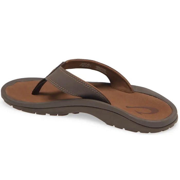The OluKai Mens Ohana Dark Java Ray sandal features a cushioned anatomical tan footbed with a subtle heel logo, water-resistant dark brown straps, and a textured sole for reliable grip, shown from the rear.