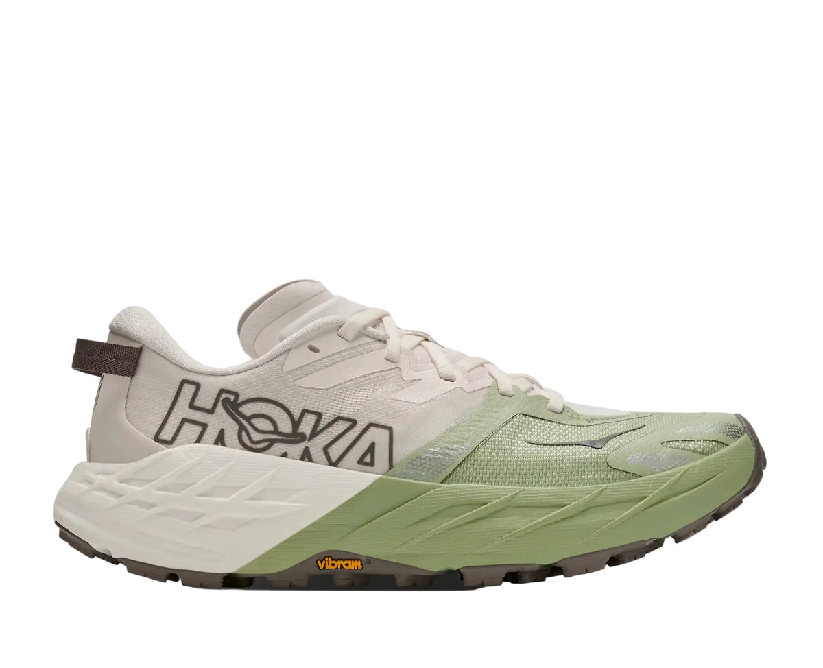 HOKA Women's Speedgoat 7 White/Green trail running shoe, woven textile upper, cushioned white midsole, angled side view.