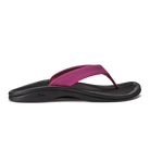 A side view of the OLUKAI W-Ohana Orchid water-resistant sandal, featuring a black sole and a magenta pink thong strap, displayed on a white background.