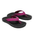 The OLUKAI W-Ohana Orchid features black water-resistant flip-flops with bright pink straps, an anatomical fit, contoured footbeds, and a simple, comfortable design, shown on a white background.
