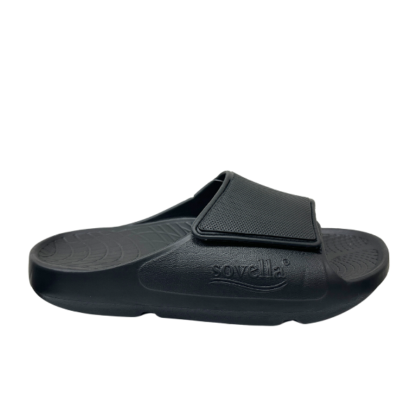 The Sovella Mens PF Velcro Slide Black features a textured footbed, adjustable strap with SOVELLA branding, and excellent arch support for comfort recovery. Shown in profile on a plain background.