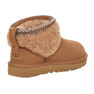 The UGG Women's Ultra Mini Maxi Chestnut is a tan suede boot with a low ankle design, plush shearling lining, decorative trim, and a flat Classic outsole. The signature UGG logo appears on the heel of these stylish curly sheepskin boots.