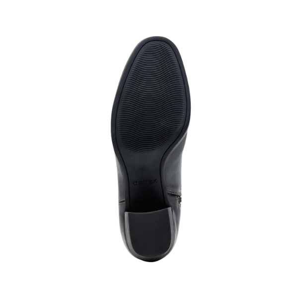 The image shows the bottom view of the Aetrex Women's Reagan Heel Boot Black by AETREX WORLDWide INC, featuring a textured, non-slip rubber sole with arch support and the brand name near the heel on a white background.