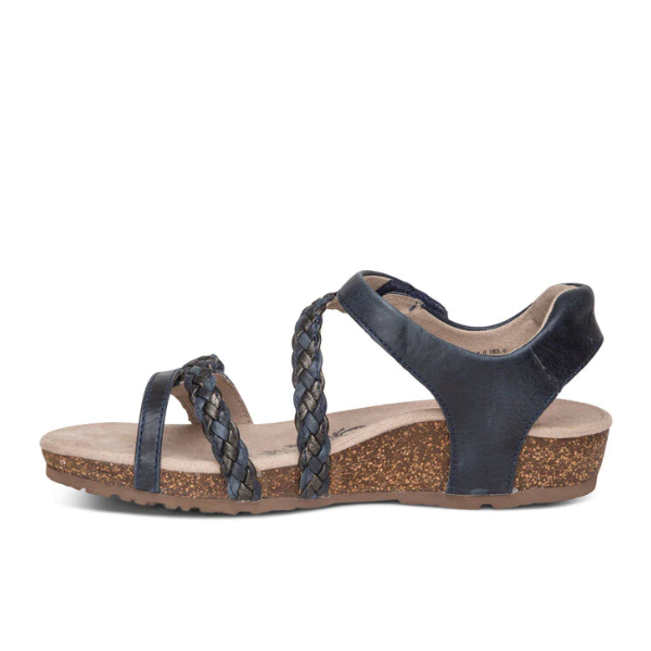 A side view of the Aetrex Womens Jillian Navy sandal features braided front straps, an ankle strap, a low cork wedge heel, and a Lynco orthotic footbed, shown on a white background.