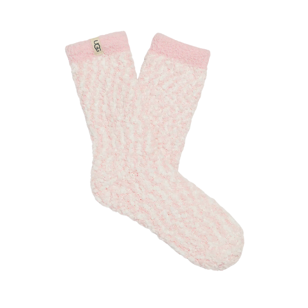 The UGG Women's Cozy Chenille Sock in Seashell is a light pink, fuzzy crew sock with a soft texture and a beige "UGG" label sewn near the top.