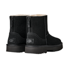 The UGG Women's Marais Zip Up Black boots feature black suede, visible stitching, sturdy soles, a soft sheepskin lining, UGG logo on the heel, and rear pull tabs for easy wear.
