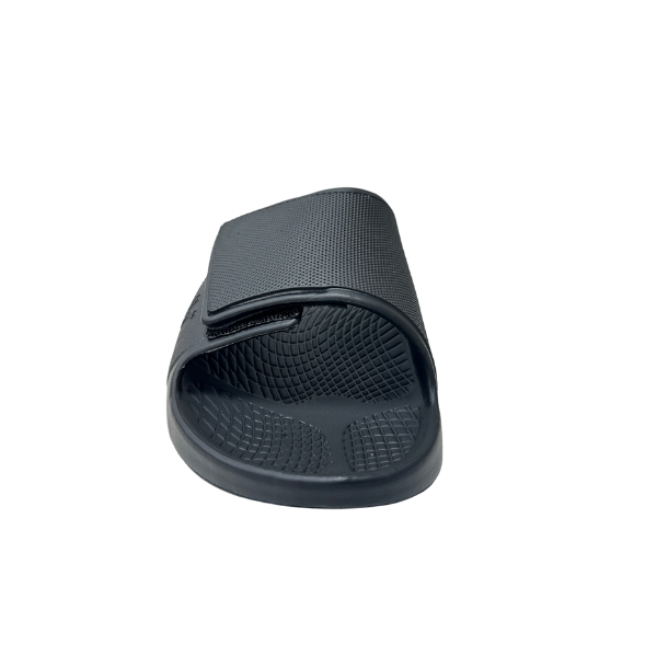 The Sovella Mens PF Velcro Slide Black by SOVELLA is shown from the front with a textured sole and Wide adjustable strap, offering arch support for comfort recovery. The sandal is displayed on a white background.