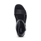 The Aetrex Women's Mae Black sandal by AETREX WORLDWide INC features a closed heel, open toe, wide front strap, ankle strap with metal buckle, and cushioned insole for comfort and foot pain relief. The insole displays the Aertex logo and curved lines.