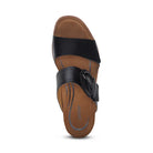 The Aetrex Women's Tatiana Black sandal by AETREX WORLDWide INC features two wide black straps—one over the toes and one with a decorative buckle—plus a supportive tan insole for foot pain relief, finished with “Aetrex” near the heel.