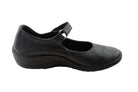 The ARCOPEDICO Womens Thy Black features a black leather Mary Jane design with a low wedge heel, single instep strap, and reliable arch support, shown from the side against a white background.