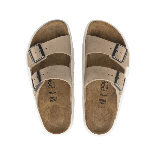 The BIRKENSTOCK Womens Arizona Chunky Sand are beige slip-on sandals with two adjustable buckle straps, contoured brown suede footbeds, and white outsoles for comfort and style.