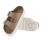 A pair of BIRKENSTOCK Womens Arizona Chunky Sand sandals in tan suede with two adjustable straps and a thick white platform sole, one upright and one on its side showing the contoured footbed and tread.