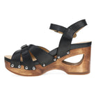 The Dansko Womens Alanna Black sandal by DANSKO features a strappy design, chunky wooden platform heel with metal rivets, and an adjustable ankle strap. The cut-out heel offers stylish support and all-day comfort.