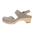 A side view of the Dansko Womens Lucia Taupe by DANSKO displays a beige suede, closed-toe clog with an adjustable ankle strap, medium stacked heel, and textured sole designed for comfort.