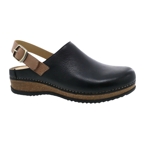 The Dansko Womens Merrin Black features black leather, a brown adjustable ankle strap, a sustainable cork midsole, and a black rubber outsole, shown in side profile against a white background.