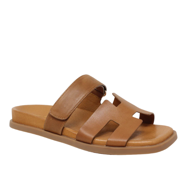 The Django & Juliette Womens Nodette Tan sandals from DJANGO & JULIETT feature thick brown leather upper straps, a flat sole, and a front cutout design for comfortable and stylish summer wear.