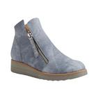 The Django & Juliette Womens Ohmy Denim bootie by DJANGO & JULIETT features gray suede, a side zipper, tan sole trim, and a low wedge heel—combining modern style with comfort ideal for casual wear or those with plantar fasciitis.