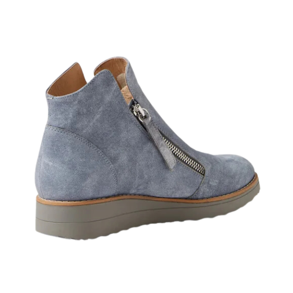 The DJANGO & JULIETT Ohmy Denim is a women’s light gray suede ankle boot with a side zipper and tan rubber sole, pictured from the rear side on a white background—crafted for comfort if you experience foot pain.