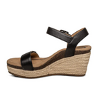 The Aetrex Womens Sydney Black Leather is a black, open-toe wedge sandal with an ankle strap, tan platform sole with braided jute, arch support, and a memory foam footbed for comfort.