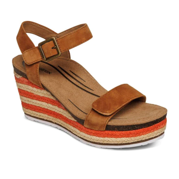 The Aetrex Womens Sydney Cognac sandal by Aetrex features brown suede, a wedge heel, adjustable espadrille ankle strap with buckle, layered tan/orange/brown striped platform, textured sole, open toe design, and arch support for comfort.