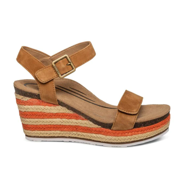 The Aetrex Womens Sydney Cognac sandal features a tan brown wedge, adjustable espadrille strap with buckle, a platform sole with orange and natural woven stripes, and a cushioned memory foam footbed.