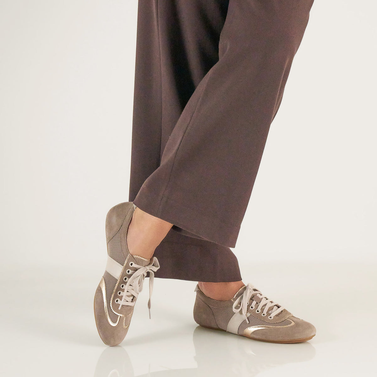 DANSKO Women's Milana Taupe/Gold Suede flat worn in a lifestyle setting, sneakerina style.