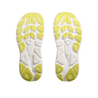 A pair of HOKA Womens Clifton 10 Wide Pink running shoe soles, shown facing upward with a white base and yellow rubber traction patterns; the left sole displays the HOKA logo, emphasizing grip and flexibility.