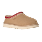 The UGG Women's Tasman II Sand is a tan suede slide with a cream rubber sole, red and white trim along the collar, and an embossed UGG logo—a stylish twist on classic women’s sheepskin slippers.