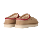UGG Women's Tasman II Sand slippers by UGG, shown from the back, feature a tan slip-on design with cream outsoles, red patterned trim around the opening, and plush lining for cozy comfort.