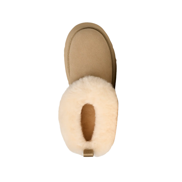 Top view of the UGG Women's Tazzelle Mustard Seed slipper, featuring a tan suede exterior and plush cream sheepskin lining, displayed on a white background.