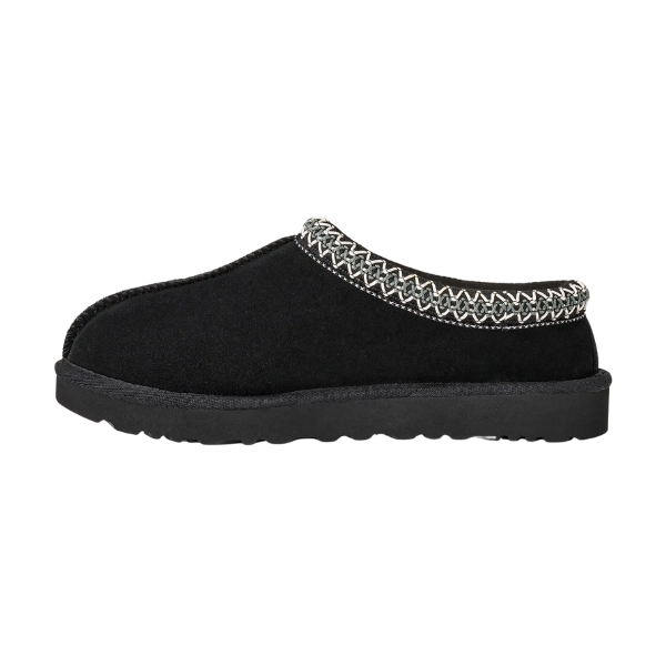 The UGG Women's Tasman II Black slipper features a thick sole and decorative white and gray zigzag stitching along the top edge, shown in side profile against a white background.