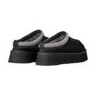 The UGG Women's Tazz II Black slippers feature thick platform soles, visible ankle stitching, and plush sheepskin lining. Shown from the back and side, these UGG suede shoes combine comfort with stylish design.
