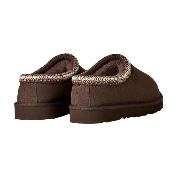 The UGG Men's Tasman II Cocoa slip-on slippers feature a suede upper, plush sheepskin lining, and decorative stitching, displayed from the back and side on a white background.