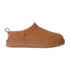 The UGG Women's Classic Micro Chestnut slipper features tan suede, a fluffy white lining, flat sole, and heel pull tab for a cozy UGG look, shown in profile on a white background.