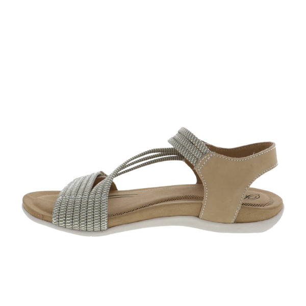 The Biza Womens Luna Sand by BIZA FOOTWEAR features beige and silver tones, a closed heel, elastic ankle strap, two thin crossing elastic straps, a textured toe band, and a flat cushioned sole for comfort and foot pain relief.