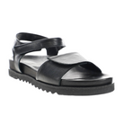 The SOVELLA Womens Chloe Black sandal showcases premium leather straps, adjustable velcro closures, and a thick ridged sole with cushioned footbed for all-day comfort, shown against a white background.