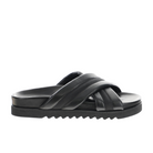 The SOVELLA Sovella Womens Coty Black is a slip-on sandal with crisscrossed padded leather straps, a thick ridged sole, and a cushioned footbed for comfort—ideal for versatile daily wear. Side view shown.