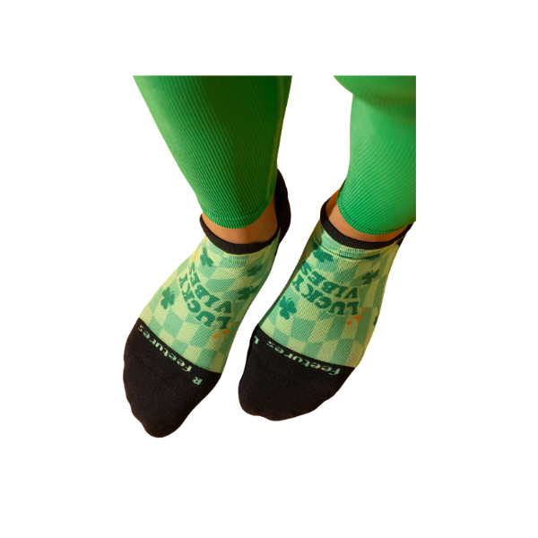 Person wearing green leggings and FEETURES Elite Light Cushion Tab - Limited Edition - Lucky Vibes socks.