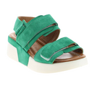 The SOVELLA Womens Maya Green sandal features green suede, a white platform sole, open toe, two adjustable Velcro straps, and a cushioned insole for all-day comfort.