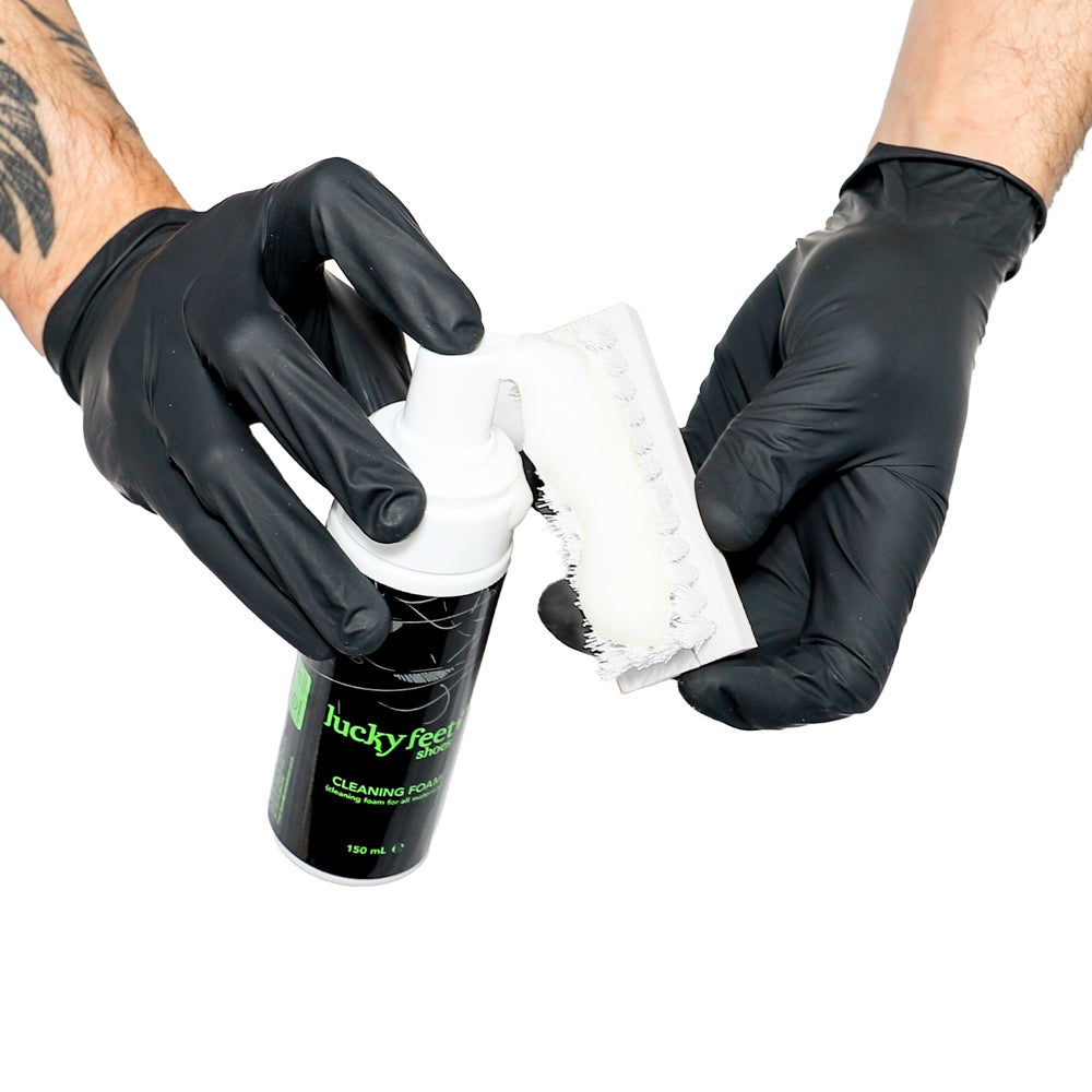 Person wearing black gloves holding a container of Lucky Pug cleaning paste.