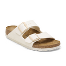 The BIRKENSTOCK Womens Arizona Birko-Flor Patent in Offwhite/Eggshell features two adjustable straps with buckles, a cork footbed, and a textured rubber sole—ideal slip-on sandals for everyday comfort.
