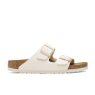 The Birkenstock Womens Arizona Birko-Flor Patent Offwhite/Eggshell sandal features two adjustable buckle straps and a cork footbed, shown in side profile on a white background.