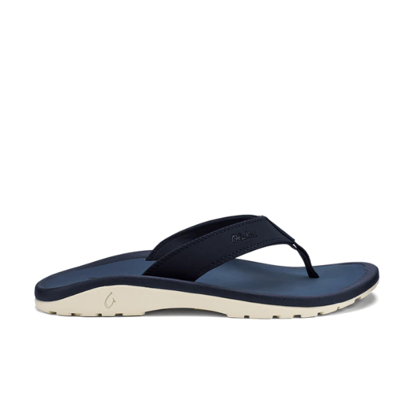 The OLUKAI Mens Ohana sandal in Deep Blue/White features a thick strap and cream-colored sole, shown in side profile against a white background. These water-resistant sandals deliver style and comfort for everyday wear.
