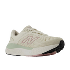 The New Balance Womens Fresh Foam X 1540v4 Wide Beige features a light pink N logo, mint green heel accent, engineered-knit upper, cushioned sole, and black/pink rubber outsole, all displayed on a white background.